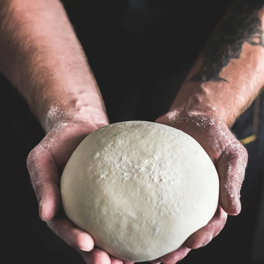 Hands holding fresh dough